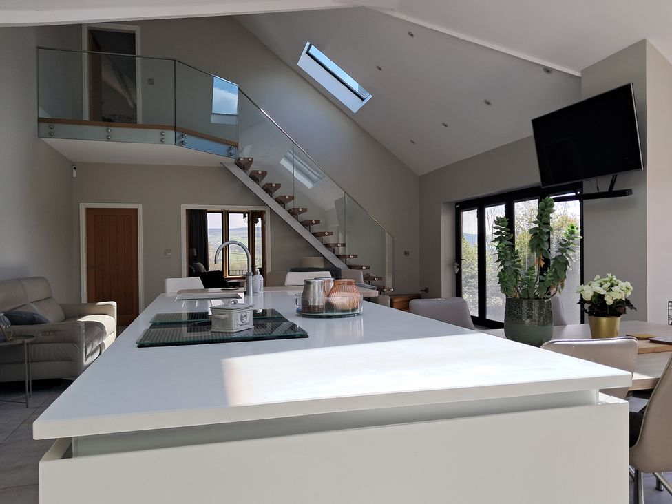 A kitchen with a staircase and a television at Castleys Mount in Skipton
