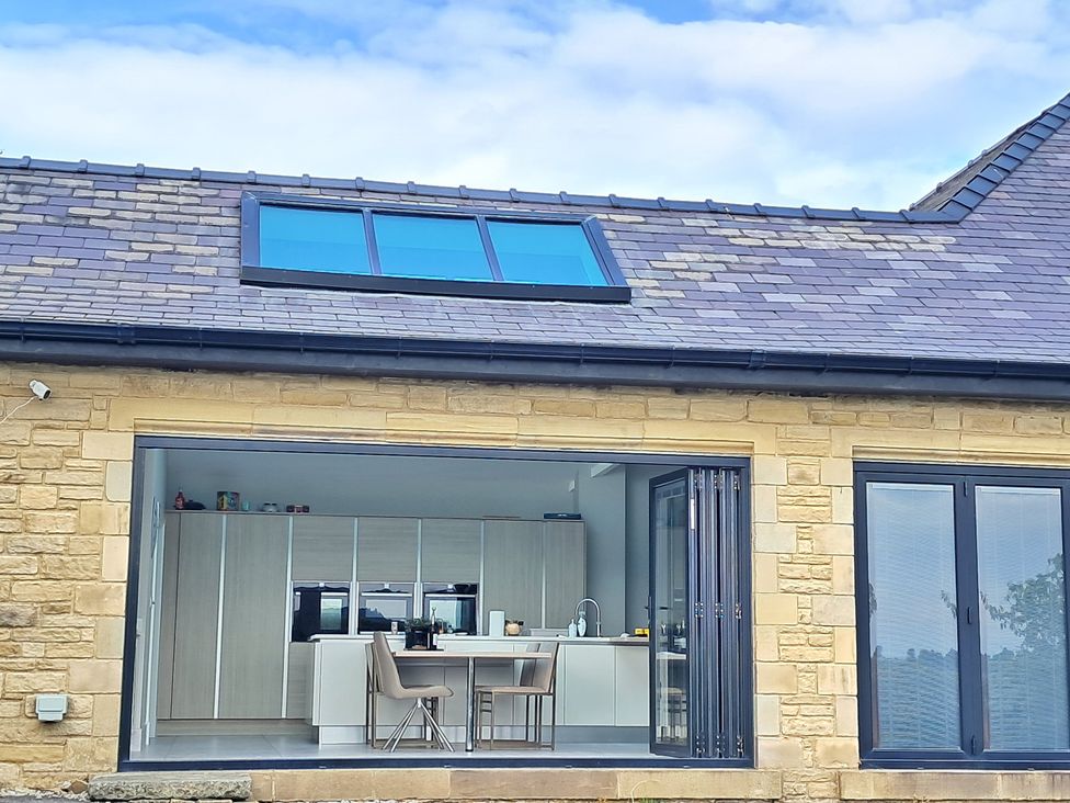 A kitchen with cabinets and a dining area at Castleys Mount, Skipton