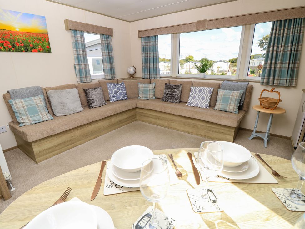 A living room with a sofa and dining table at Beach Retreat