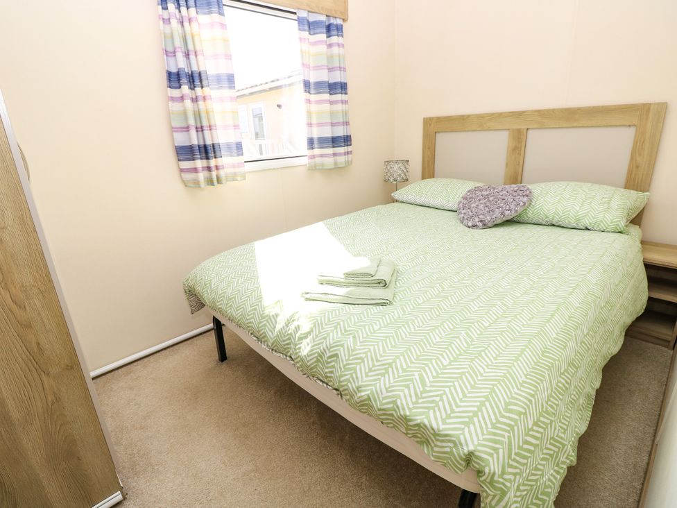 A bedroom with a double bed and window at Beach Retreat