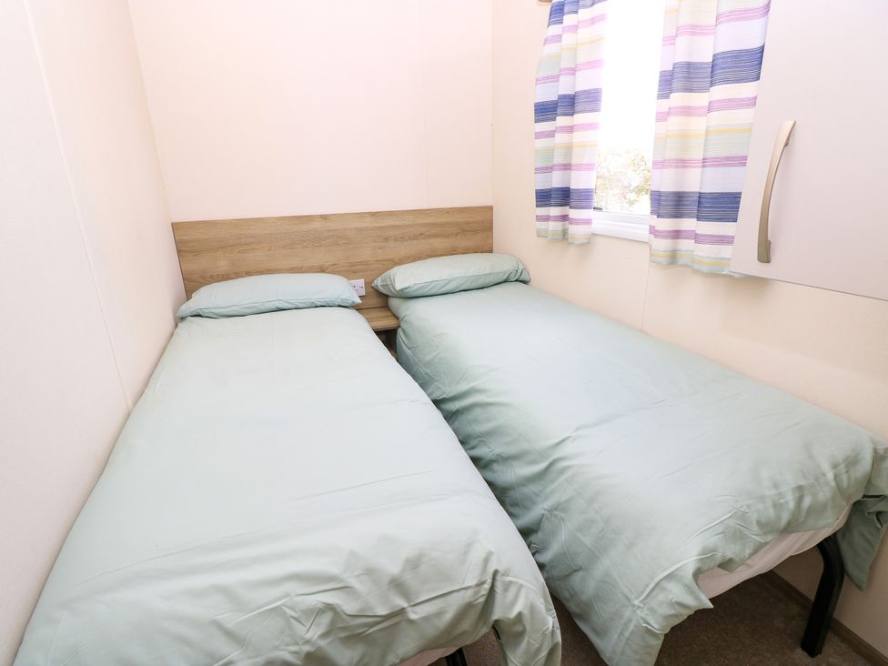 A bedroom with two single beds and colorful curtains at Beach Retreat in 