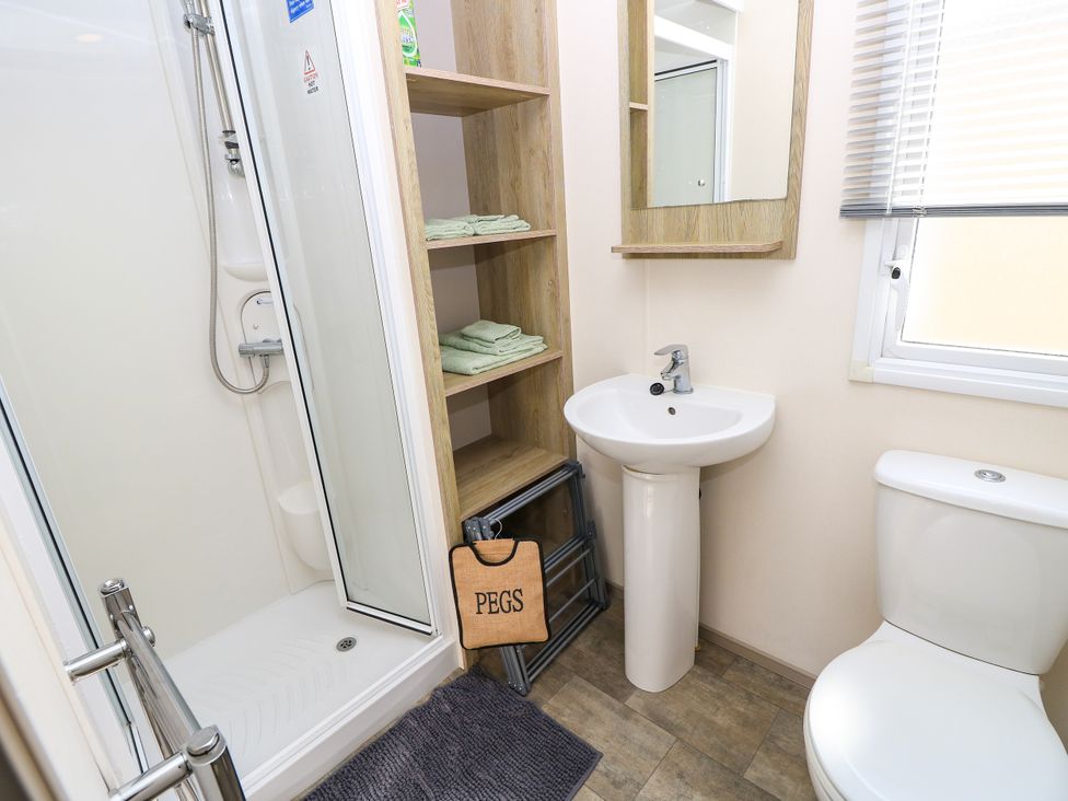 A bathroom with a shower, sink, and toilet at Beach Retreat