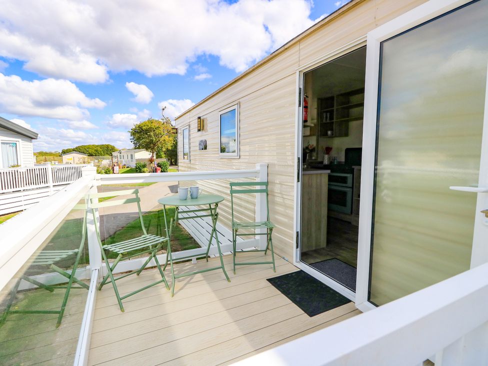 A balcony with seating and a table at Beach Retreat in 