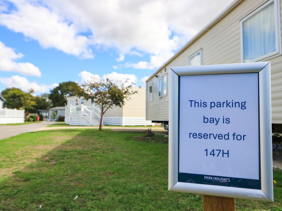 A parking sign stating reserved for 147H at Beach Retreat