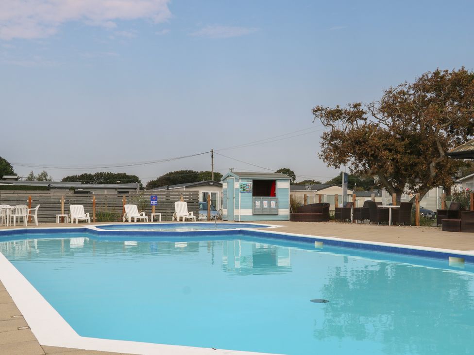 An outdoor pool area with lounge chairs and a cabana at Beach Retreat 