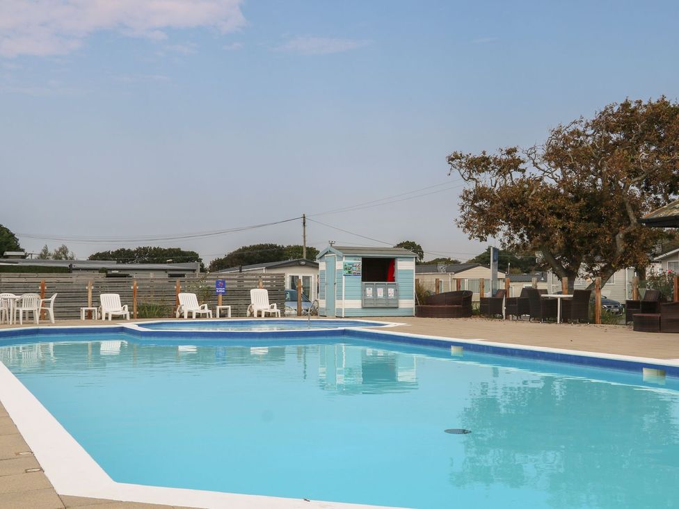 An outdoor area with a swimming pool and chairs at Beach Retreat in Warsash