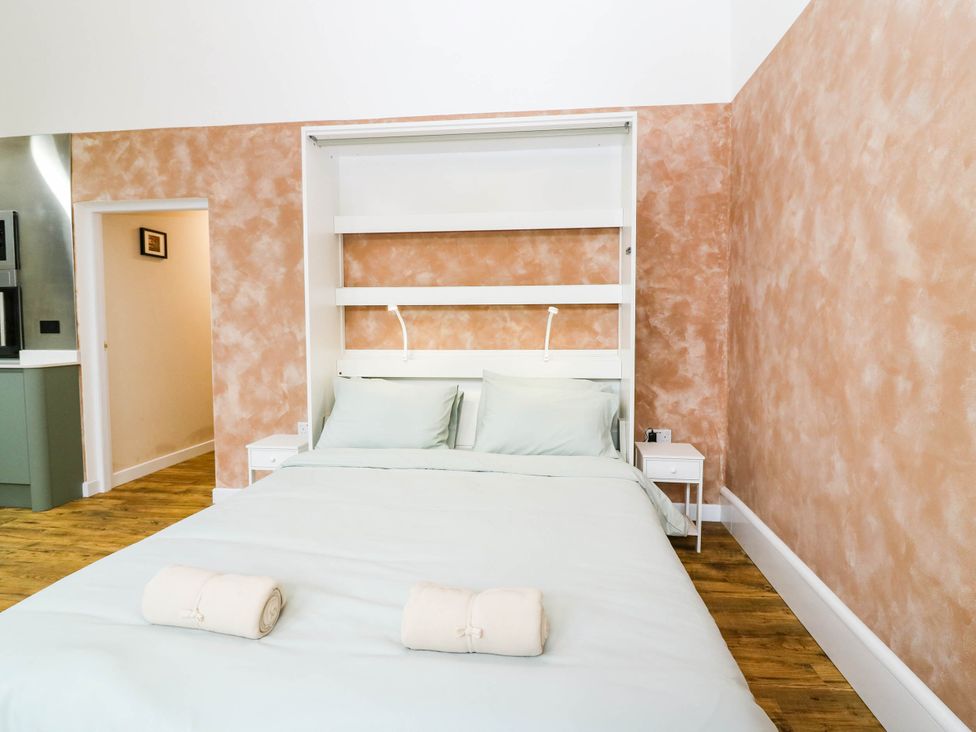 A bedroom with a bed and bedside table at The Studio @ 18 in Milnathort