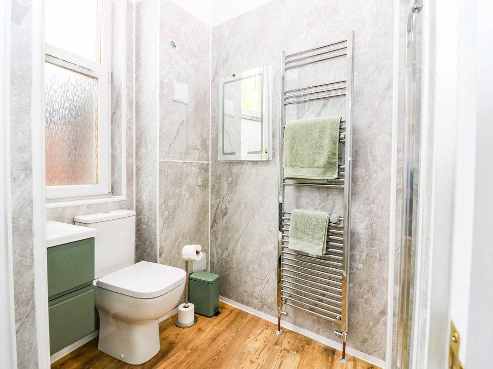 A bathroom with a toilet, sink, and towel rack at The Studio @ 18 Milnathort