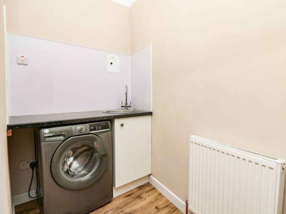 A laundry room with a washing machine and sink at The Studio @ 18 Milnathort