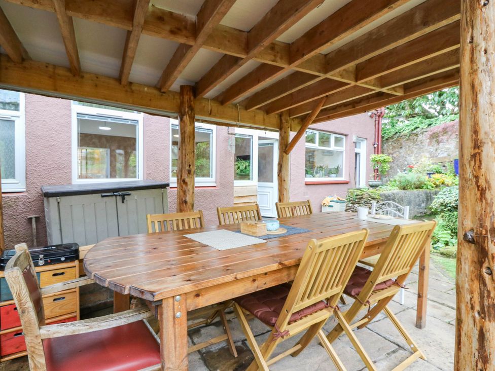 An outdoor dining area with a wooden table and chairs at The Studio @ 18 in Milnathort