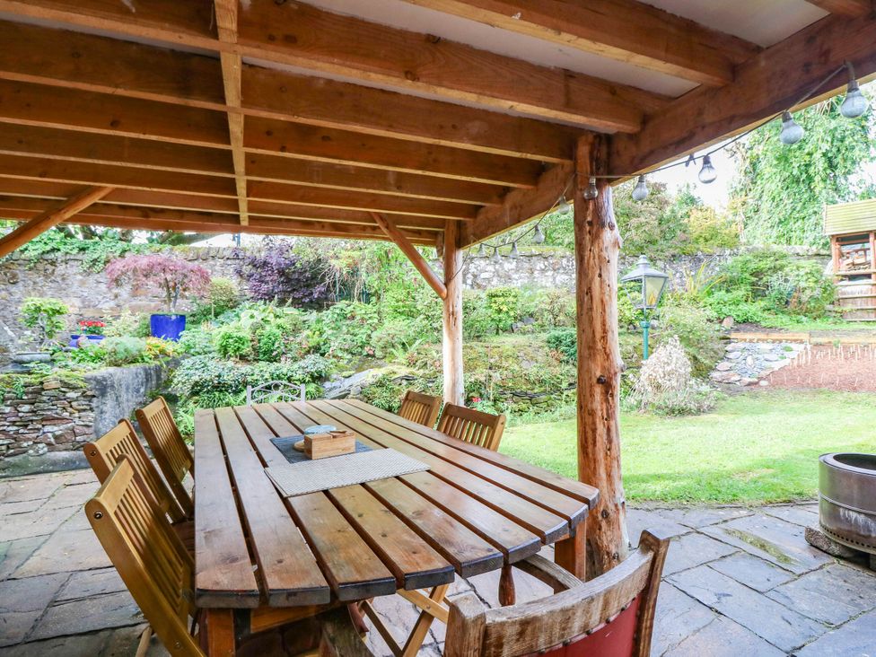 An outdoor dining area with a wooden table and chairs at The Studio @ 18 Milnathort