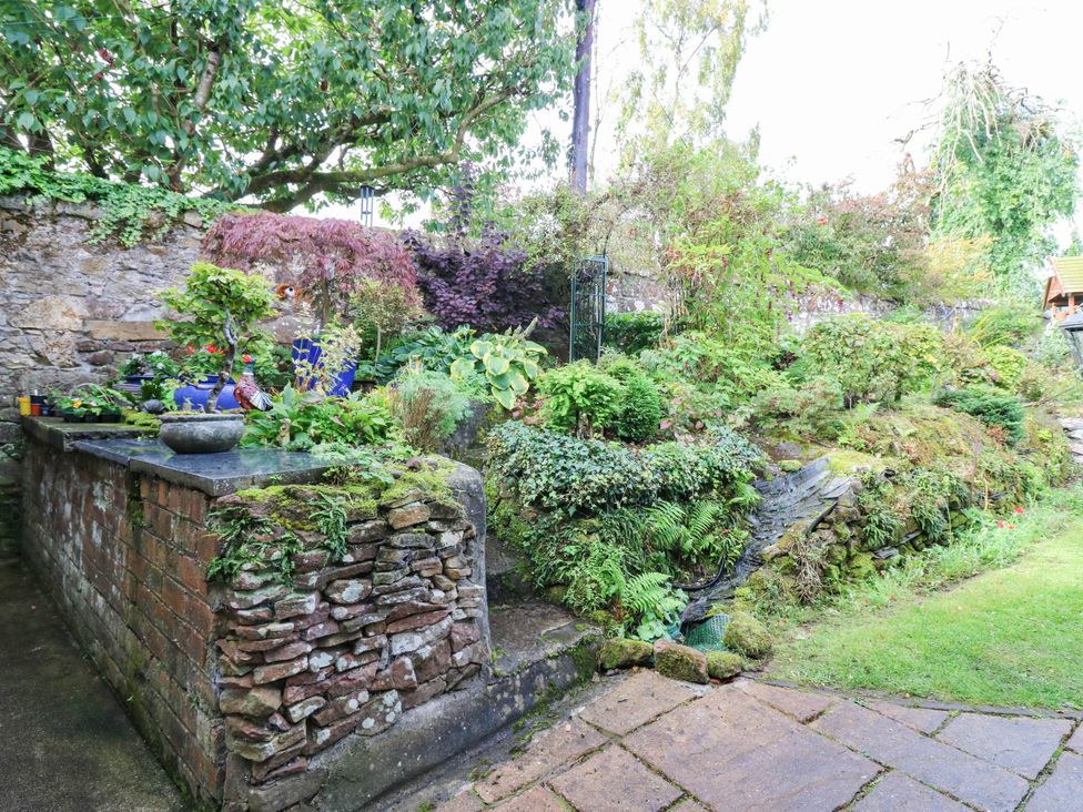 A garden with plants and a stone wall at The Studio @ 18 Milnathort