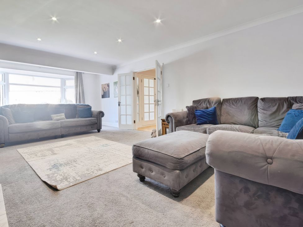 A living room with sofas and an ottoman at Gralyn Place