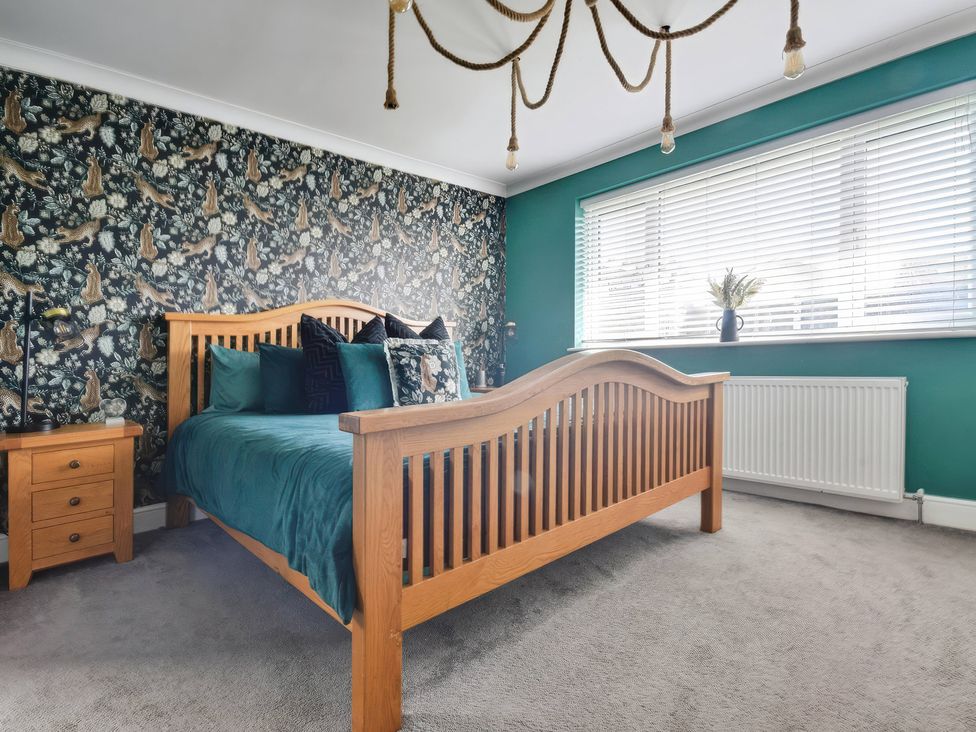A bedroom with a wooden bed and nightstand at Gralyn Place