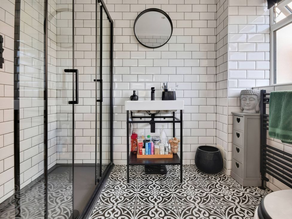 A bathroom with shower, sink and storage unit at Gralyn Place