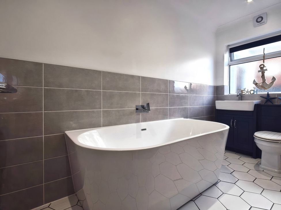 A bathroom with a bathtub, toilet, and sink at Gralyn Place