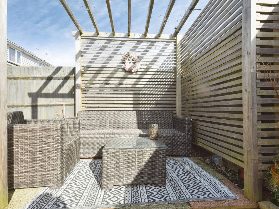 An outdoor seating area with furniture and a decorative wreath at Gralyn Place 