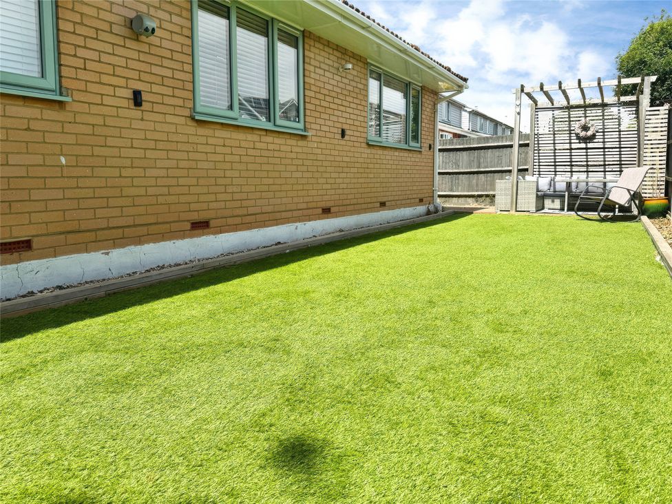 A garden with artificial grass and a pergola at Gralyn Place 