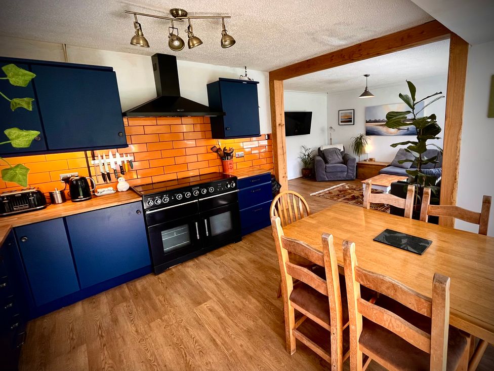 A kitchen with a dining table and a view of a living area at Ty Marlyn St Davids
