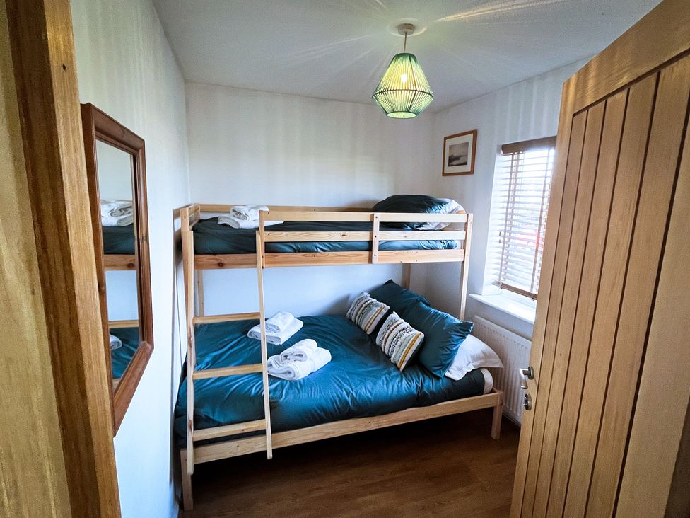 A bedroom with a bunk bed and a double bed at Ty Marlyn in St Davids
