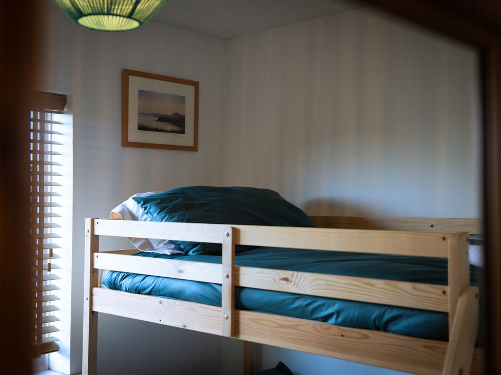 A bunk bed with a pillow and blanket at Ty Marlyn in St Davids