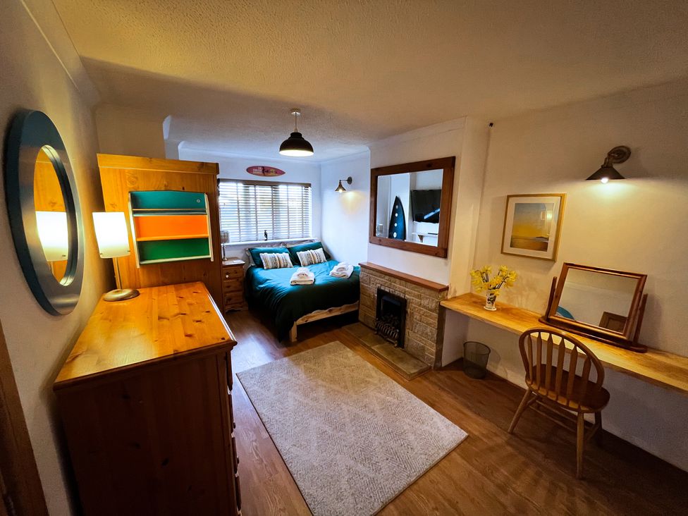 A bedroom featuring a bed, dresser, and workspace at Ty Marlyn in St Davids