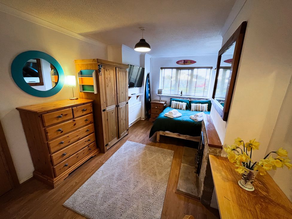 A bedroom with a bed and dresser at Ty Marlyn in St Davids