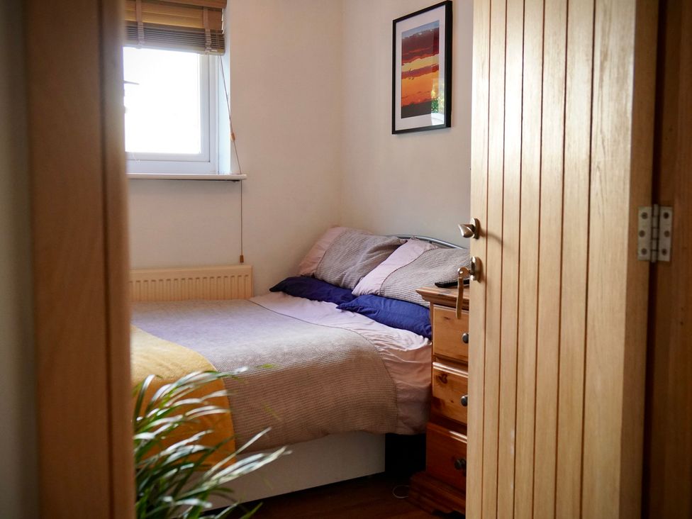 A bedroom with a bed and a dresser at Ty Marlyn in St Davids