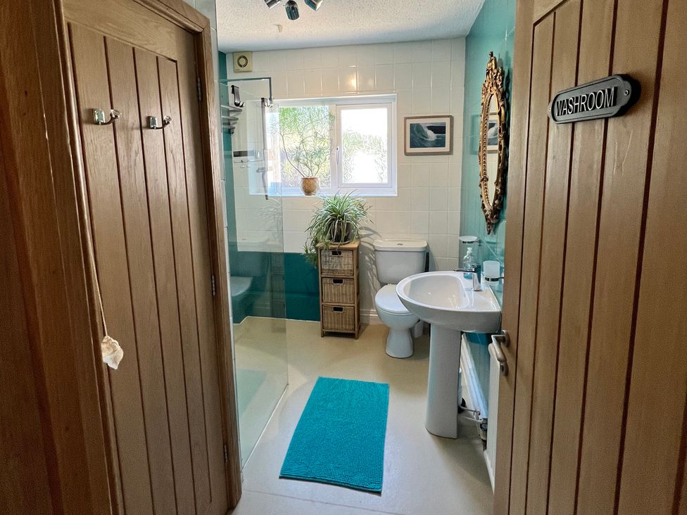 A washroom with a toilet, sink, and shower at Ty Marlyn in St Davids