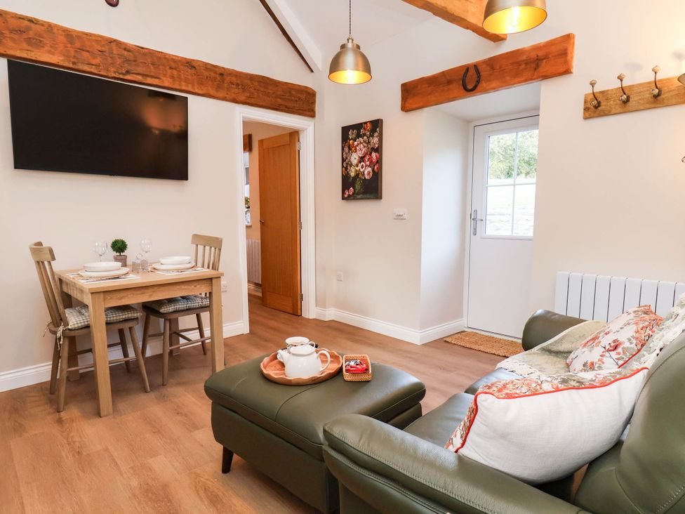 A living room with a sofa and a dining table at Tawny Cottage in Scarborough
