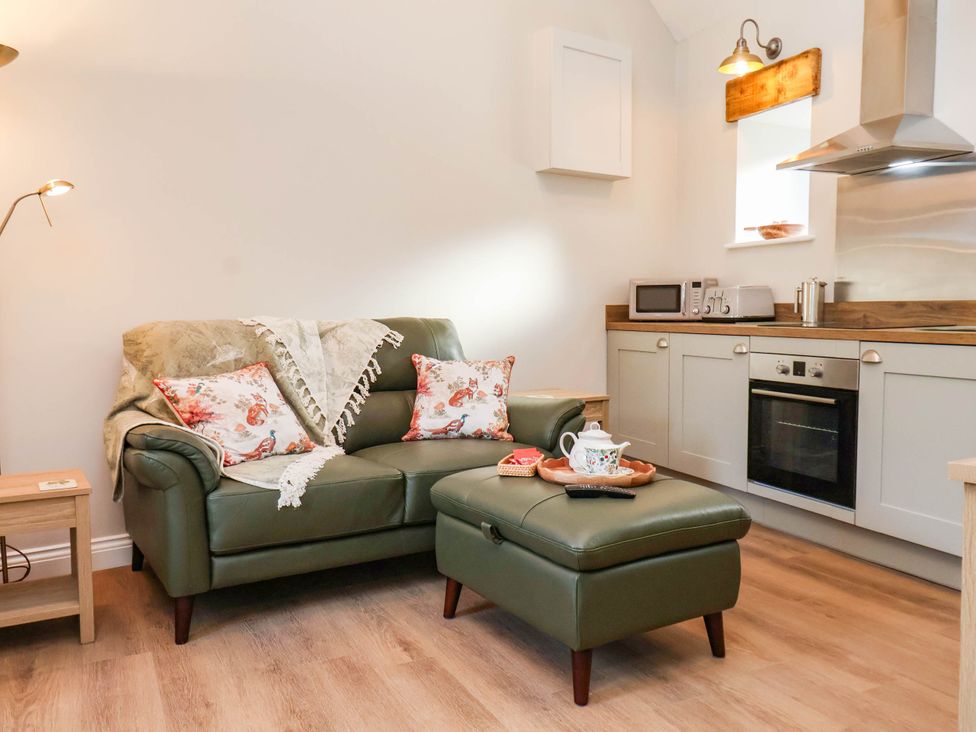 A living room with a sofa and coffee table at Tawny Cottage Scarborough