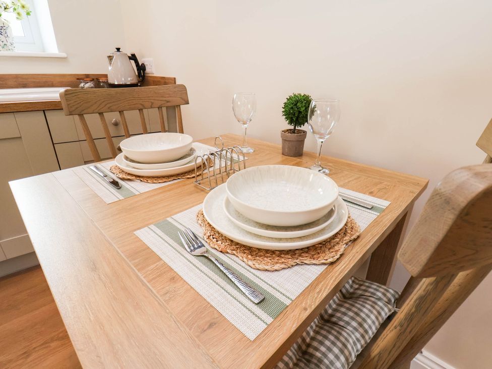 A dining table set with plates and glasses at Tawny Cottage in Scarborough