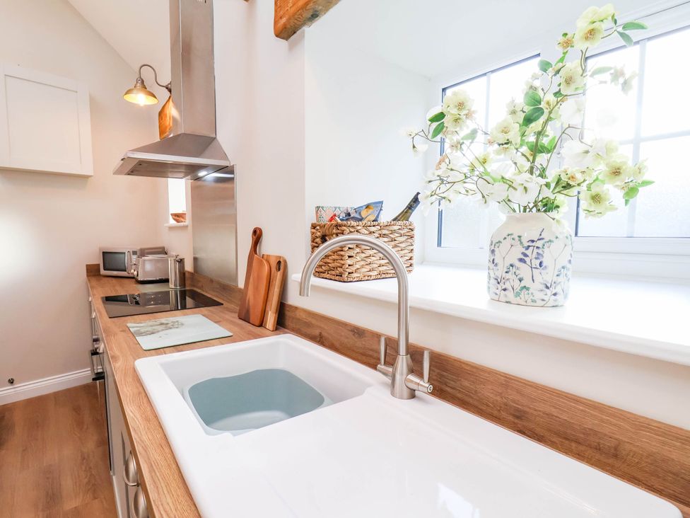 A kitchen with a sink and cooking surface at Tawny Cottage in Scarborough