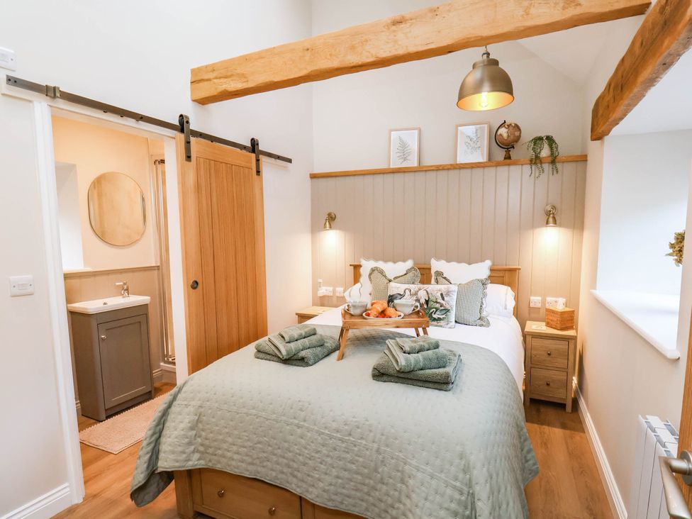 A bedroom with a bed and side table at Tawny Cottage in Scarborough
