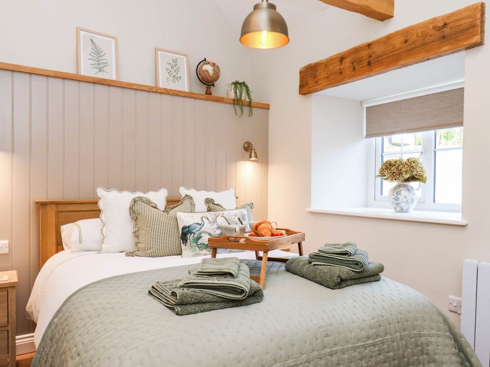 A bedroom with a bed and bedside table at Tawny Cottage in Scarborough