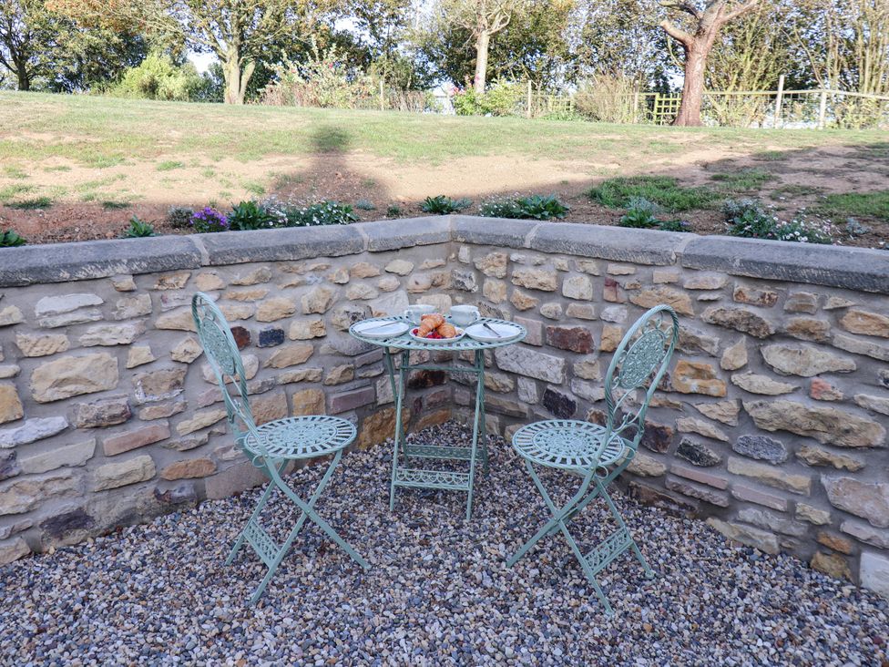 An outdoor seating area with a table and two chairs at Tawny Cottage in Scarborough