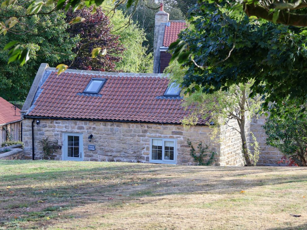 A cottage with a red roof and windows at Tawny Cottage in Scarborough