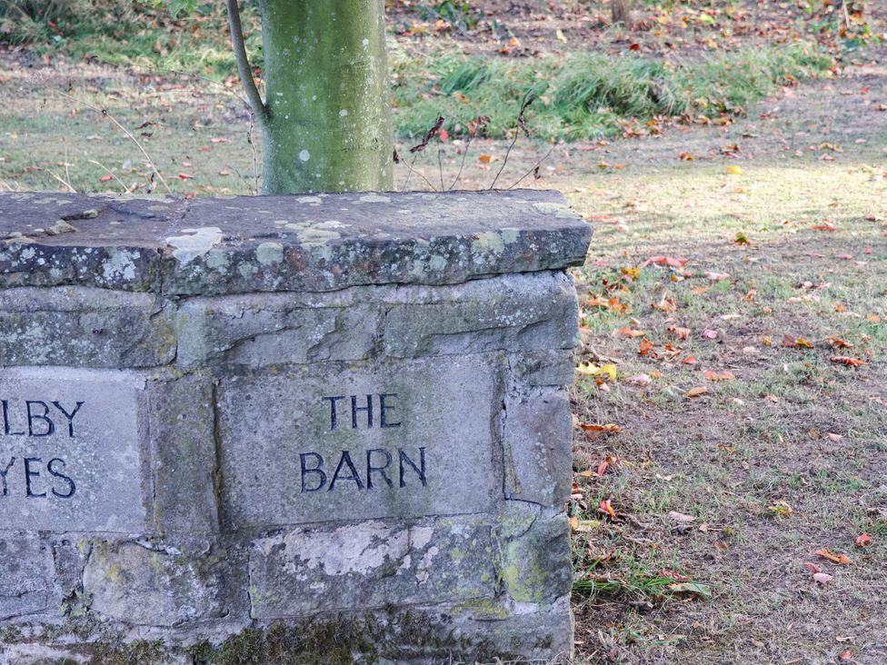 A stone wall with the words THE BARN at Tawny Cottage Scarborough