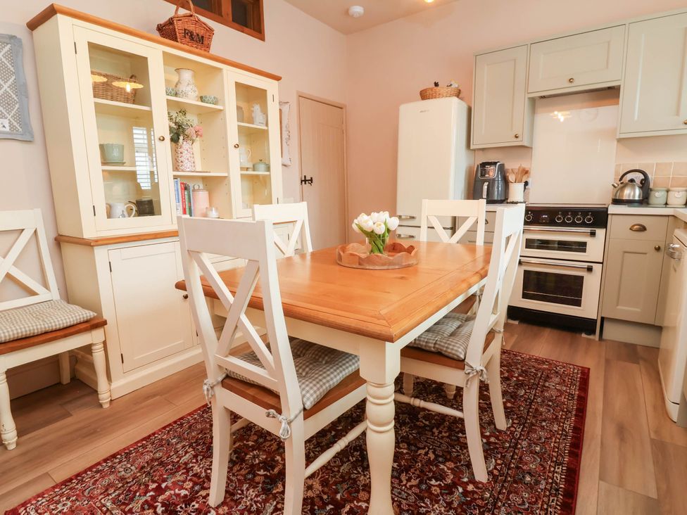 A kitchen with a dining table and chairs at Myrtle Cottage in Lynmouth