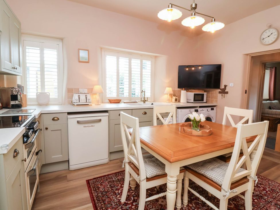 A kitchen with a dining table and appliances at Myrtle Cottage in Lynmouth