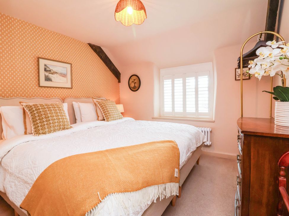 A bedroom with a bed and decorative accessories at Myrtle Cottage in Lynmouth