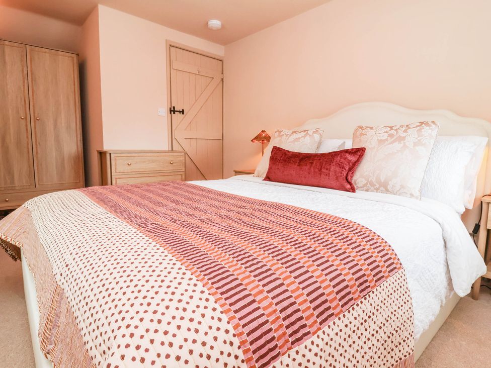 A bedroom with a bed and wardrobe at Myrtle Cottage in Lynmouth