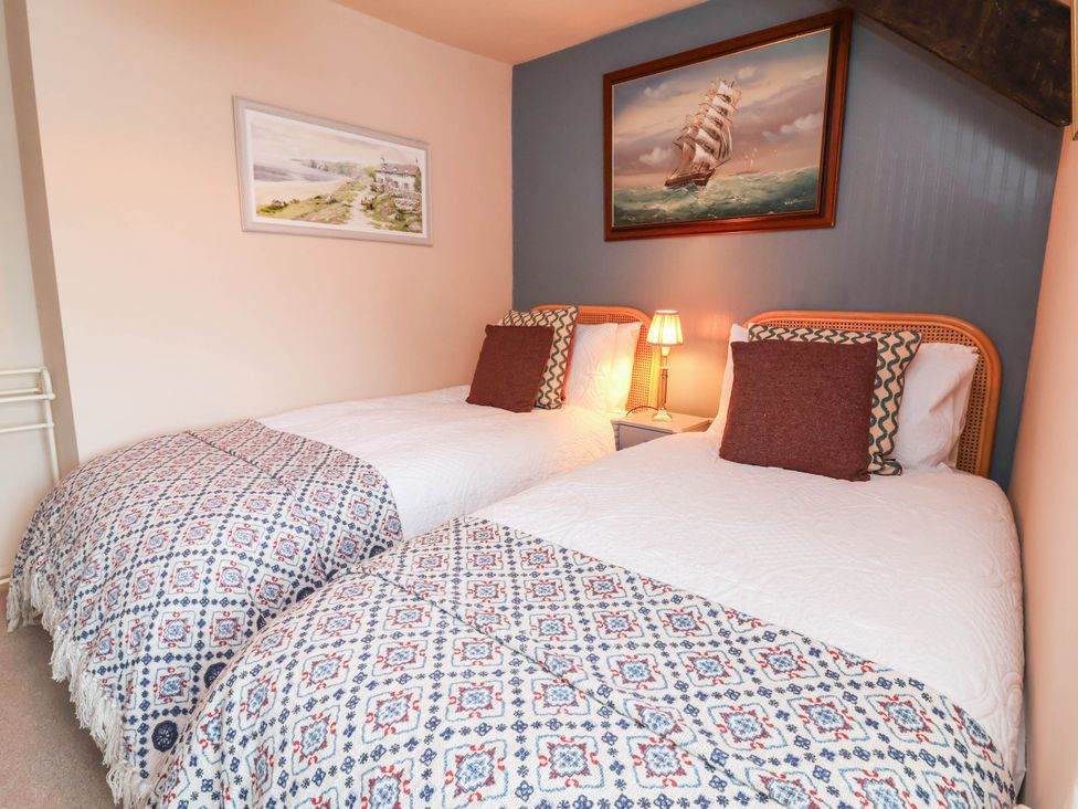 A bedroom with twin beds and a lamp at Myrtle Cottage in Lynmouth