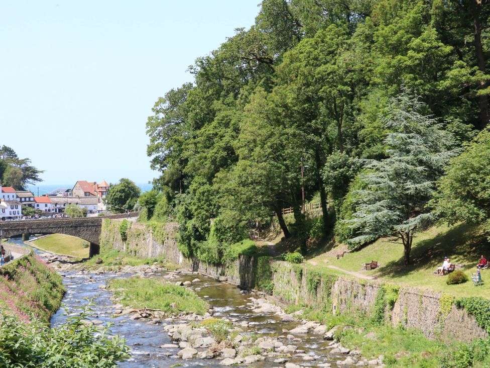 A view of a river with trees and a bridge at Myrtle Cottage in Lynmouth