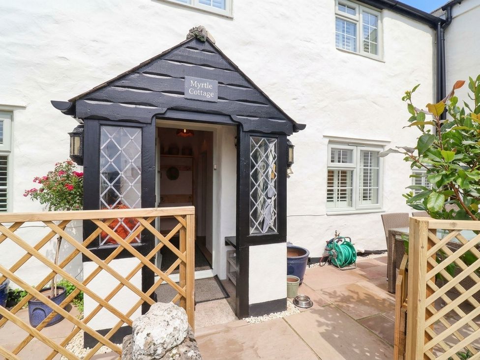 An entrance with a door and sign at Myrtle Cottage in Lynmouth