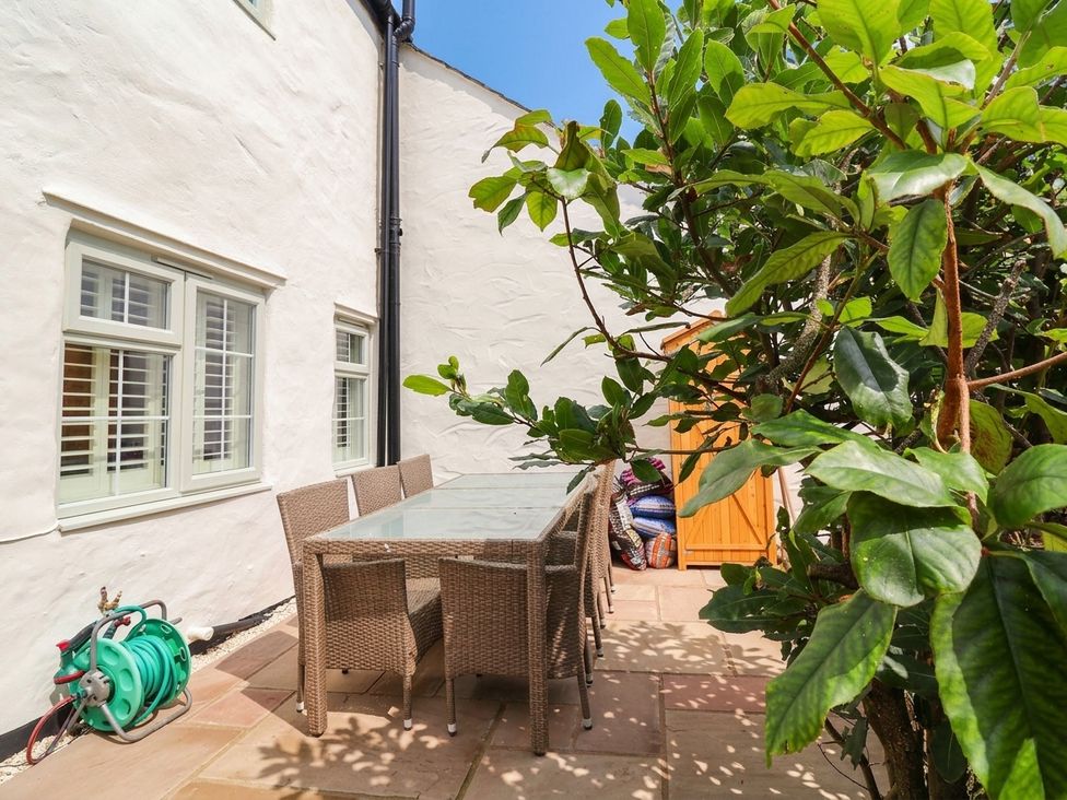 An outdoor patio with a dining table and chairs at Myrtle Cottage in Lynmouth
