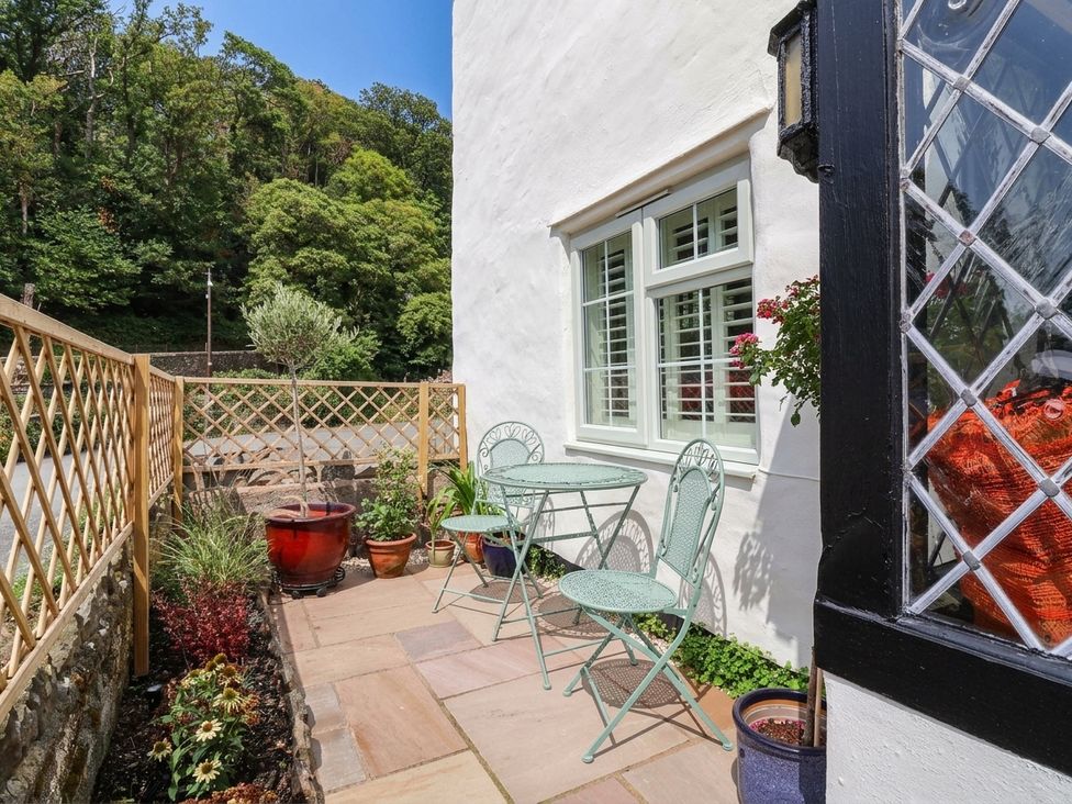 An outdoor area with a table and chairs at Myrtle Cottage in Lynmouth