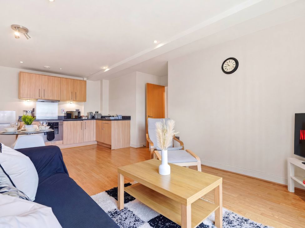A living room with a kitchen in the background at Apartment 28 in Birmingham