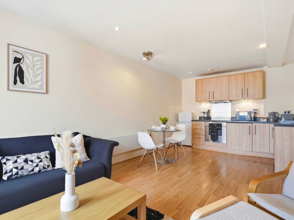 A living room with a kitchen area at Apartment 28 Birmingham