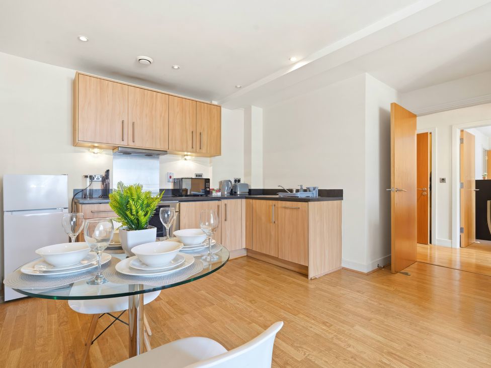 A kitchen with cabinets and dining area at Apartment 28 in Birmingham